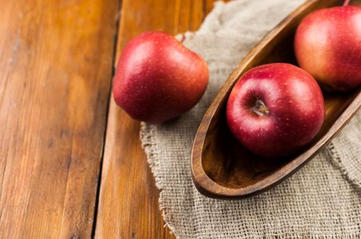 red ripe organic healthy apples in bowl on wooden board. Healthy food