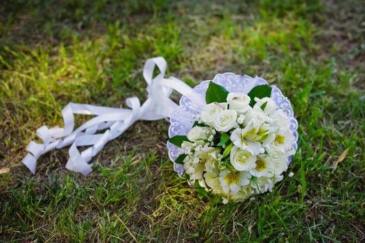 Bridal wedding bouquet of flowers. Wedding bouquet of yellow and white roses lying on a grass
