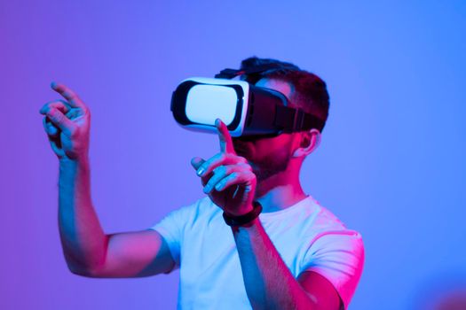 Young bearded man playing virtual reality game using VR goggles