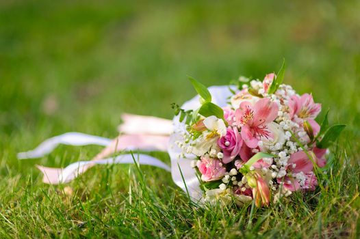 Bridal wedding bouquet of flowers. Wedding bouquet of yellow and white roses lying on a grass