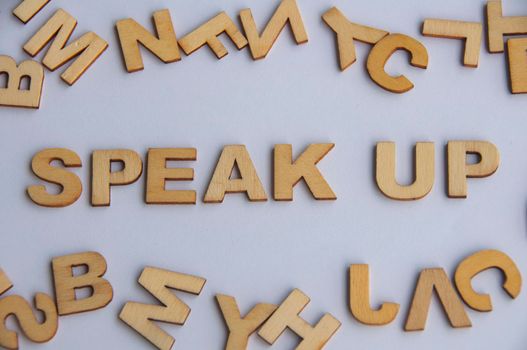 Speak up wooden text on while cover background. Courage concept.