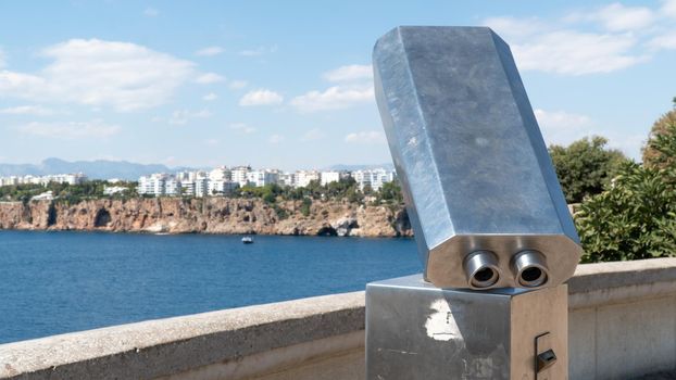 Stationary viewing binoculars in the park with a view of the city and the rocks. High quality photo