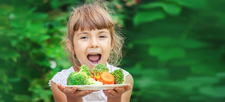 child eats vegetables. Summer photo. Selective focus nature