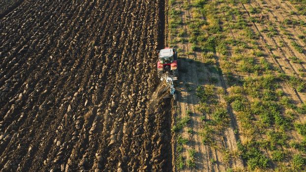 Aerial view with drone of tractor plowing the land in the countryside.