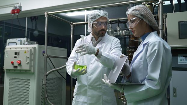 Two scientist in professional uniform working in laboratory for chemical and biomedical experiment