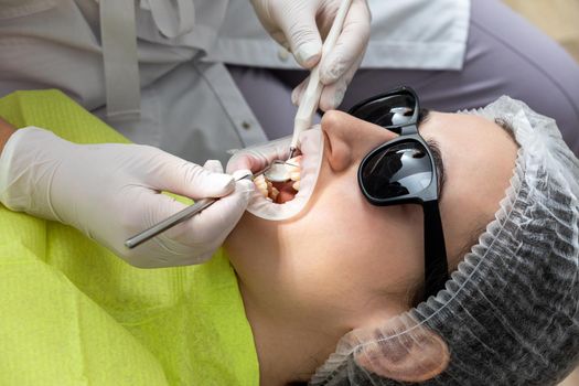 Dentist Examining Patient's Mouth with dental mirror In Clinic. Checkup concept