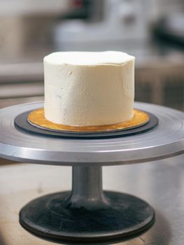 professional baker decorating a chocolate and cream cake with salty caramel