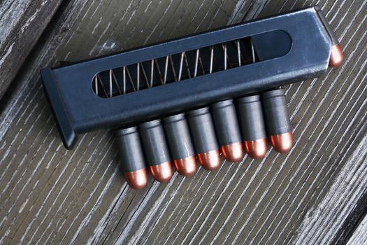 Handgun cartridges closeup on old wooden background