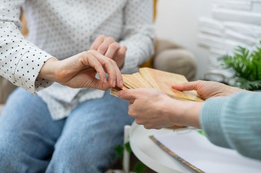 Psychologist uses metaphorical associative cards in a session with a patient. Close-up of female hands