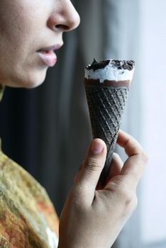 young women eating chocolate flavor ice cream .