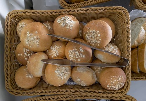 Delicious buns are on the table in a wicker basket. Top view, close-up.