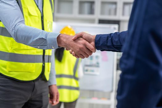 After concluding the meeting, competent investor shakes hands with engineer. Concept of the agreement between engineers and investors.