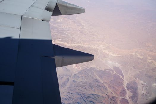 Airplane wing in the air against a blue sky