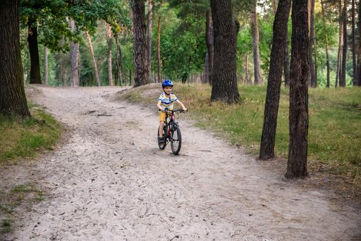 Cyclist Riding down the sandy Hill on the Offroad Trail.