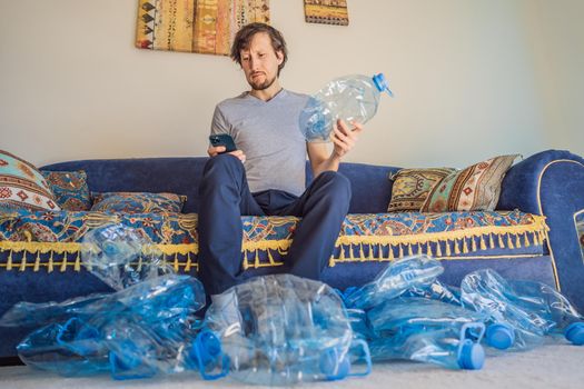 Young caucasian man hamong empty plastic bottles to recycle with sad expression.