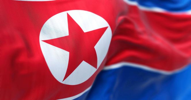 Close-up view of the North Korea national flag waving in the wind. The Democratic People Republic of Korea is a country in East Asia. Fabric textured background. Selective focus