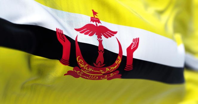 Close-up view of the Brunei national flag waving in the wind. Brunei Darussalam is a country in the Southeast Asia. Fabric textured background. Selective focus