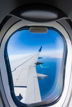 Plane wing with eluminator against the blue of the sky