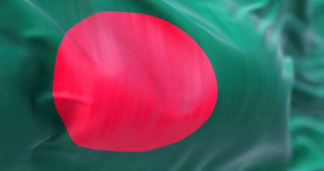 Close-up view of the Bangladesh national flag waving in the wind. People Republic of Bangladesh, is a country in South Asia. Fabric textured background. Selective focus