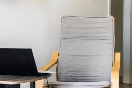 Shot of an arm chair, coffee table and laptop on it