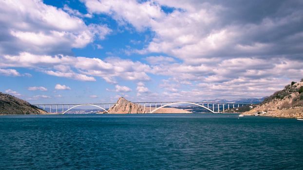 Krk Bridge, Croatian: Krcki most is a 1,430 m, 4,692 ft, long reinforced concrete arch bridge connecting the Croatian island of Krk to the mainland. Grey clouds with storm incoming