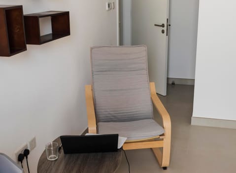 Shot of an arm chair, coffee table and laptop on it