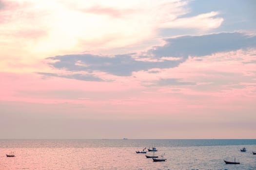 Beautiful sunrise on sea background with tropical wooden fishing boat pink tone