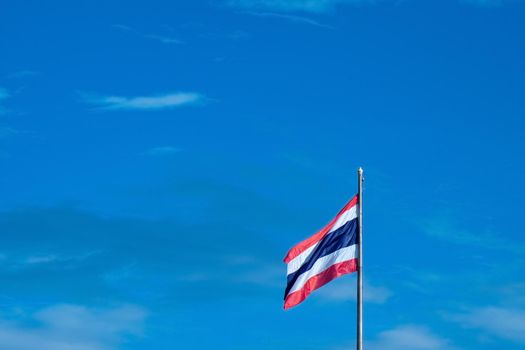 National Flag of Thailand on pole against nature blue sky background.