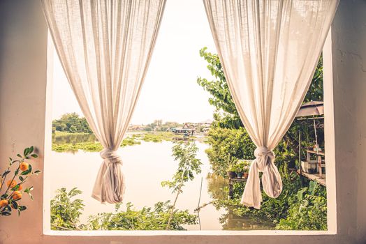 white linen curtain with window view green from river tree landscape