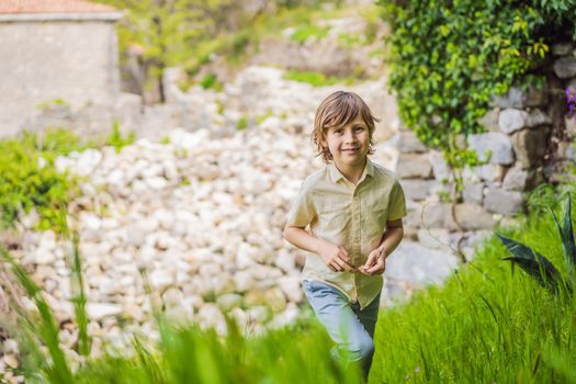 Boy tourist walks through the old town of Bar in Montenegro. Happy tourist walks in the mountains. Suburbs of the city of Bar, Montenegro, Balkans. Beautiful nature and landscape.
