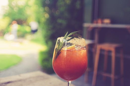 Fresh summer drink mocktail pour in glass on blur cafe bachground.