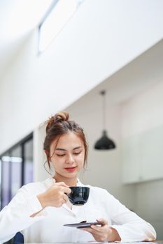 Portrait of a beautiful young woman working on a computer, documenting budget and drinking coffee during a review of the company's investment and earnings financial statements on her desk