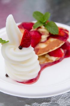 Strawberry waffles with vanilla ice cream on plate