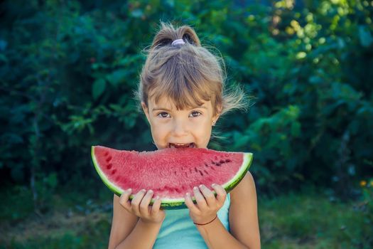 The child eats watermelon in summer. Selective focus. People.