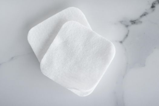 Cosmetology, cleanliness and branding concept - Organic cotton pads on marble background, cosmetics and make-up remover, hygiene and skincare beauty brand product for healthcare and medical design