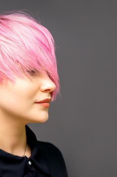 Profile of a beautiful young caucasian woman with short straight bob hairstyle dyed in pink color with closed eyes with copy space