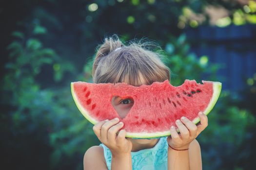 The child eats watermelon in summer. Selective focus. People.