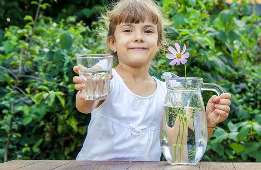 The child drinks clean water in summer. Selective focus. People.