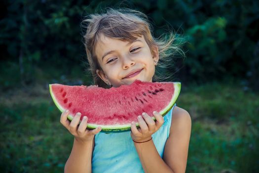 The child eats watermelon in summer. Selective focus. People.