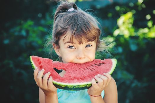 The child eats watermelon in summer. Selective focus. People.