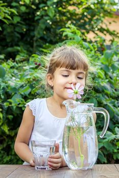 The child drinks clean water in summer. Selective focus. People.