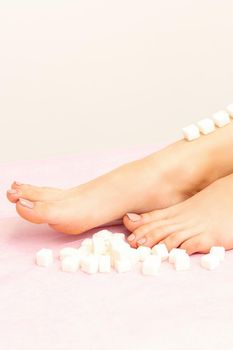 The concept of epilation, waxing. Sugar cubes lie down in a row on the naked white female leg