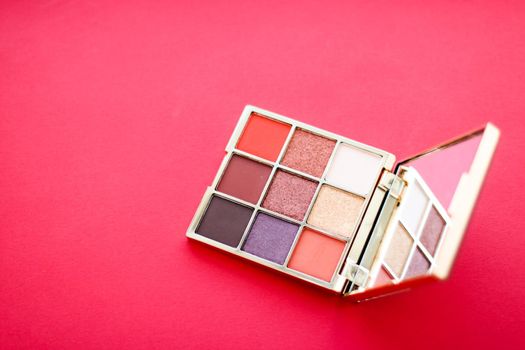 Cosmetic branding, mua and girly concept - Eyeshadow palette and make-up brush on red background, eye shadows cosmetics product for luxury beauty brand promotion and holiday fashion blog design