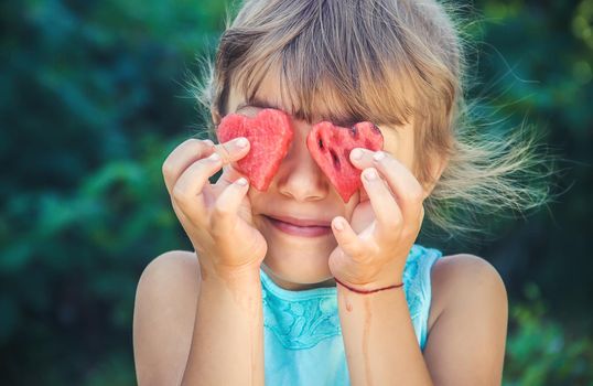 The child eats watermelon in summer. Selective focus. People.