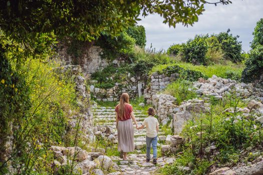 Mom and son tourists walks through the old town of Bar in Montenegro. Happy tourist walks in the mountains. Suburbs of the city of Bar, Montenegro, Balkans. Beautiful nature and landscape.