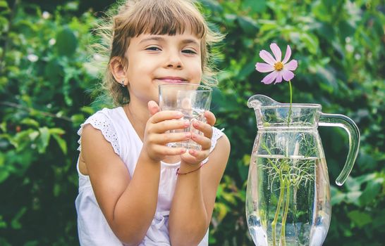 The child drinks clean water in summer. Selective focus. People.