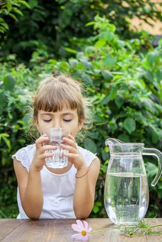 The child drinks clean water in summer. Selective focus. People.