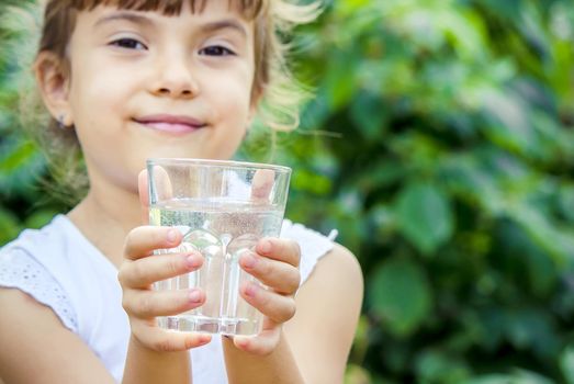 The child drinks clean water in summer. Selective focus. People.