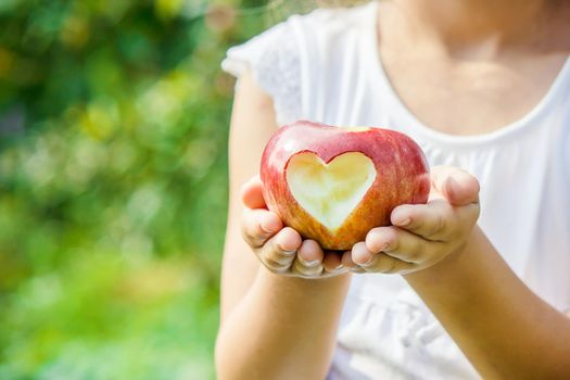 Child with an apple. Selective focus. Garden Food