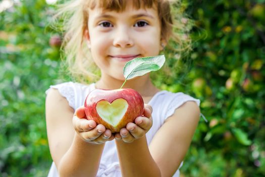 Child with an apple. Selective focus. Garden Food